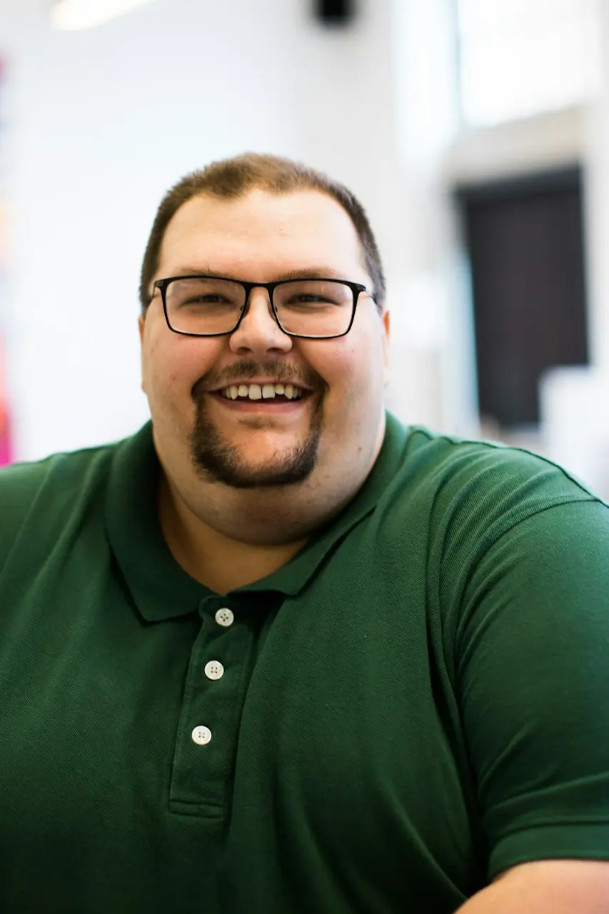 man sitting down wearing green polo shirt